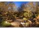 Beautiful backyard oasis featuring mature desert landscaping, a charming pergola, and relaxing water features at 25002 N Quail Haven Dr, Rio Verde, AZ 85263