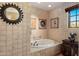 Bathroom featuring a round tub, tile surround, and natural light at 25002 N Quail Haven Dr, Rio Verde, AZ 85263