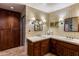 Bathroom featuring dual sinks with a marble countertop and wooden cabinetry at 25002 N Quail Haven Dr, Rio Verde, AZ 85263