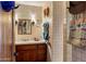 Cozy bathroom featuring a wood vanity, beige tile walls, and decorative hats at 25002 N Quail Haven Dr, Rio Verde, AZ 85263