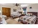 Well-lit bedroom featuring two beds, a ceiling fan, and a decorative chair at 25002 N Quail Haven Dr, Rio Verde, AZ 85263