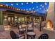 Inviting outdoor patio with a cozy fireplace, comfortable seating, and ambient string lighting, perfect for entertaining at 25002 N Quail Haven Dr, Rio Verde, AZ 85263