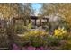 Desert garden featuring native plants and a wooden pergola with stone benches underneath and pavers leading up to it at 25002 N Quail Haven Dr, Rio Verde, AZ 85263