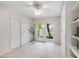 Bright bedroom featuring tile floors, ceiling fan, backyard access, and ample closet space at 2514 E Montebello Ave, Phoenix, AZ 85016