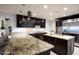 Modern kitchen featuring granite countertops, dark wood cabinetry, and stainless steel appliances at 2514 E Montebello Ave, Phoenix, AZ 85016