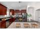 Well-equipped kitchen featuring dark wood cabinets, granite countertops, and a breakfast bar at 2525 E Misty Willow Ln, Phoenix, AZ 85024