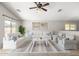 Open living room featuring neutral decor, ceiling fan, and two large windows at 2525 E Misty Willow Ln, Phoenix, AZ 85024