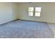 Spacious bedroom with neutral carpet, two windows and soft, neutral wall colors at 25678 N Boreas Rd, Florence, AZ 85132