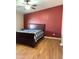 Cozy bedroom featuring a dark red accent wall and ceiling fan at 27575 N Dolores Pl, San Tan Valley, AZ 85144