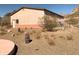 Exterior view of home showing stucco walls, desert landscaping, and mountain views at 27575 N Dolores Pl, San Tan Valley, AZ 85144