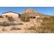 Exterior view of a single-story home with a desert landscape, showcasing the property's setting near a mountain at 27575 N Dolores Pl, San Tan Valley, AZ 85144