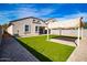 Beautiful backyard featuring artificial grass, a paved patio area, and a block fence for privacy at 3029 S 78Th Dr, Phoenix, AZ 85043