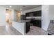 This open kitchen features black cabinets, an island, and granite countertops at 3029 S 78Th Dr, Phoenix, AZ 85043