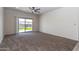 Spacious carpeted living room with backyard access via sliding glass doors and pergola views at 3029 S 78Th Dr, Phoenix, AZ 85043