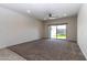 Carpeted living room with sliding glass doors offering backyard views and natural light at 3029 S 78Th Dr, Phoenix, AZ 85043