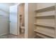 A walk-in closet with ample shelving and storage space, leading to a separate water closet at 3029 S 78Th Dr, Phoenix, AZ 85043