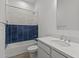 Modern bathroom with blue-and-white tiled shower, sleek vanity, and contemporary fixtures at 32489 N 135Th Dr, Peoria, AZ 85383