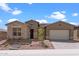 Charming single-story home featuring stone accents, a two-car garage, and a landscaped front yard at 32489 N 135Th Dr, Peoria, AZ 85383