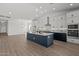 Open-concept kitchen featuring white cabinets, stainless steel appliances, and a contrasting navy blue island at 32489 N 135Th Dr, Peoria, AZ 85383