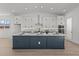 Stylish kitchen boasts white cabinets, granite countertops, stainless appliances, and a large navy blue island at 32489 N 135Th Dr, Peoria, AZ 85383