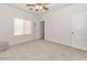 Bright bedroom features neutral carpet, a ceiling fan, and a large window for ample natural light at 330 E Cheyenne Rd, San Tan Valley, AZ 85143