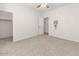 Spacious bedroom with neutral carpet, a ceiling fan, and an adjacent entrance to a walk-in closet at 330 E Cheyenne Rd, San Tan Valley, AZ 85143