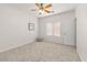 Cozy bedroom features neutral carpet, a ceiling fan, and a window for ample natural light at 330 E Cheyenne Rd, San Tan Valley, AZ 85143