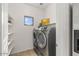 Bright laundry room with modern washer and dryer, floating shelves, and a window at 330 E Cheyenne Rd, San Tan Valley, AZ 85143