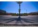 Neighborhood entrance roundabout with palm tree and houses under a clear blue sky at 3648 E Perkinsvile St, Gilbert, AZ 85295