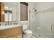 Well-lit bathroom with modern shower, toilet and sink with bright countertop and wooden cabinets at 37200 N Cave Creek Rd # 1072, Scottsdale, AZ 85262