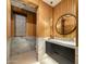 Stylish powder room featuring wood walls, marble accents and a sleek black vanity at 37200 N Cave Creek Rd # 1072, Scottsdale, AZ 85262