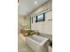 Close-up of a soaking tub with a marble countertop vanity, designer fixtures, and a neutral stone wall at 37200 N Cave Creek Rd # 1072, Scottsdale, AZ 85262