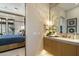 A modern bathroom with a stylish vanity with a marble countertop, a bedroom view, and gold fixtures at 37200 N Cave Creek Rd # 1072, Scottsdale, AZ 85262