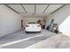 Spacious garage featuring a white car, concrete flooring, and ample storage space at 378 W Satinka Dr, San Tan Valley, AZ 85140