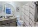 A bathroom features a round mirror, beige walls, and a shower with a patterned curtain at 39935 N Passaro Dr, San Tan Valley, AZ 85140