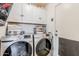 Well-equipped laundry room featuring a washer, dryer, and ample storage space with white cabinets at 39935 N Passaro Dr, San Tan Valley, AZ 85140