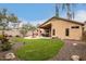 Expansive backyard featuring a covered patio, outdoor kitchen, fire pit, and lush artificial turf at 40656 N Key Ln, Anthem, AZ 85086