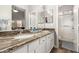 Bathroom featuring double sinks with granite countertops and a separate shower stall at 40656 N Key Ln, Anthem, AZ 85086