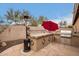 Outdoor kitchen featuring a grill, counter space, and a red umbrella in a landscaped backyard at 40656 N Key Ln, Anthem, AZ 85086