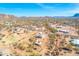 Expansive aerial view captures a desert home with horse property, scenic mountain views, and sunny Arizona skies at 4188 N Plaza Dr, Apache Junction, AZ 85120