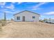 Rear exterior view of white desert home with a brown roof, desert landscape, truck and trailer at 4188 N Plaza Dr, Apache Junction, AZ 85120