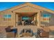 A covered patio with an outdoor kitchen and seating area for entertaining in the backyard at 4459 E Warlander Ln, San Tan Valley, AZ 85140