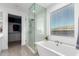 Bright bathroom featuring a soaking tub, glass enclosed shower, and large window with natural light at 4459 E Warlander Ln, San Tan Valley, AZ 85140