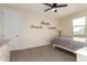 Cozy bedroom with carpet, a ceiling fan, a window, and minimalist decor with mounted shelves at 4459 E Warlander Ln, San Tan Valley, AZ 85140