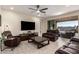 Inviting living room featuring tile floors, leather furniture, a ceiling fan and sliding glass doors leading to outdoor patio at 4459 E Warlander Ln, San Tan Valley, AZ 85140