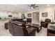 Open-concept living room with tile floors, leather furniture, ceiling fan, and adjacent kitchen space at 4459 E Warlander Ln, San Tan Valley, AZ 85140