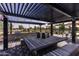 Outdoor kitchen and dining area with a built-in grill and shaded seating at 4459 E Warlander Ln, San Tan Valley, AZ 85140