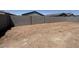 View of a spacious backyard enclosed by a tall block fence and dirt ground ready for landscaping at 46886 W Old Timer Rd, Maricopa, AZ 85139