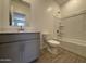 Bathroom with a combination tub and shower, gray vanity, and wood-look tile flooring at 46886 W Old Timer Rd, Maricopa, AZ 85139