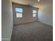 Sunlit bedroom featuring two windows, neutral walls, and plush carpeting at 46886 W Old Timer Rd, Maricopa, AZ 85139